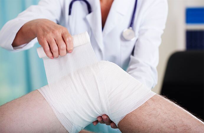 un médecin panse l'articulation du genou pour l'arthrose